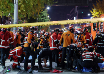 Rescue workers and firefighters work on the scene of a crushing accident in Seoul, South Korea, Saturday, Oct. 29, 2022. South Korean officials say dozens of people were in cardiac arrest after being crushed by a large crowd pushing forward on a narrow street during Halloween festivities in the capital Seoul. (Lee Ji-eun/Yonhap via AP)