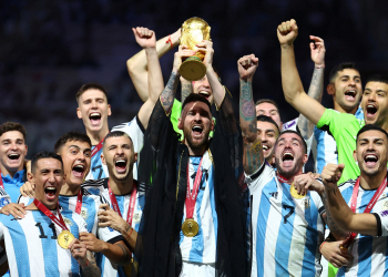 Soccer Football - FIFA World Cup Qatar 2022 - Final - Argentina v France - Lusail Stadium, Lusail, Qatar - December 18, 2022 Argentina's Lionel Messi lifts the World Cup trophy alongside teammates as they celebrate after winning the World Cup REUTERS/Kai Pfaffenbach